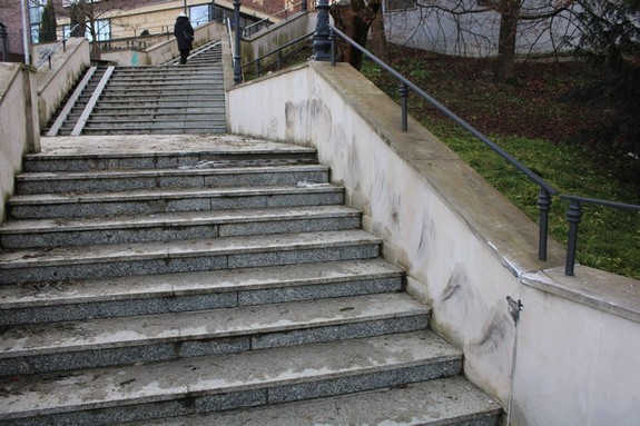 Zdjęcie schodów, które zostały uszkodzone przez kierującego bmw na ul. Blich w Krośnie. Na pionowych fragmentach przychodowych ścian oporowych, widoczne otarcia w ciemnym kolorze