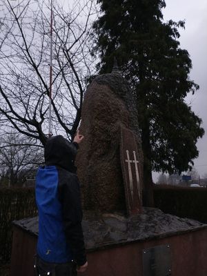Sprawca wskazuje miejsce na pomniku z którego oderwał się krzyż.