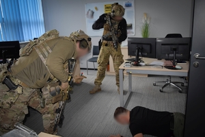 Policjanci podczas ćwiczeń w jednej z firm w Jasionce. Policyjni kontrterroryści z bronią przeszukują pomieszczenia biurowe.