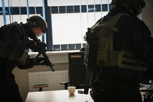 Policjanci podczas ćwiczeń w jednej z firm w Jasionce. Policyjni kontrterroryści z bronią przeszukują pomieszczenia biurowe.
