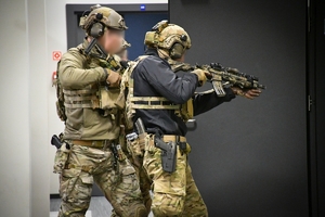 Policjanci podczas ćwiczeń w jednej z firm w Jasionce. Policyjni kontrterroryści z bronią przeszukują pomieszczenia biurowe.
