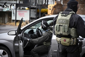 Policjanci podczas ćwiczeń w jednej z firm w Jasionce. Policyjni kontrterroryści z bronią przeszukują pomieszczenia biurowe.