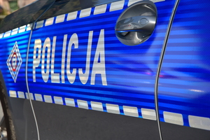 Bok policyjnego radiowozu z napisem policja