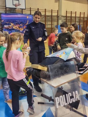 Na zdjęciu policjantka w umundurowaniu wraz z dziećmi z półkolonii.