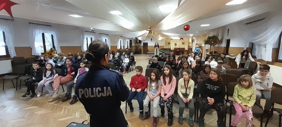 policjantka omawia dzieciom zasady bezpiecznego zimowego wypoczynku