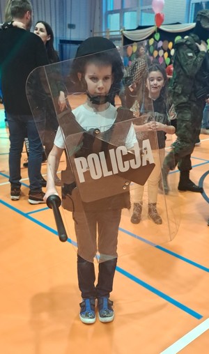 Dziecko ubrane w wyposażenie do służby policjanta