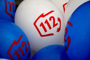 Białe i niebieskie balony z czerwonym napisem 112