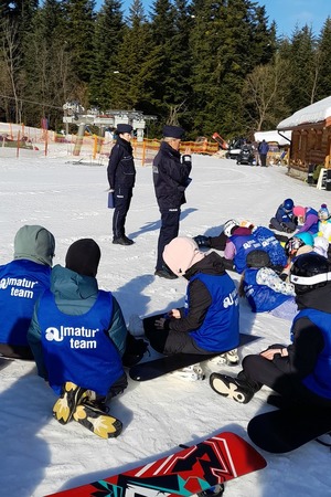 policjantki na stoku narciarskim opowiadają o bezpieczeństwie małym narciarzom
