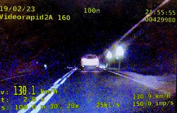 Kadr z nagrania wideorejestratora dokumentujący przekroczenie prędkości przez kierującego samochodem osobowym. W lewym dolnym rogu prędkość pojazdu 130,1 km/h.