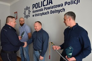 Komendant Powiatowy Policji w Ustrzykach Dolnych wręcza upominki emerytom