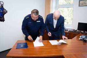 Komendant Policji podpisujący porozumienie z dyrektorem szpitala.