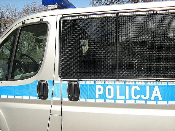 Policyjny oznakowany radiowóz. Na szybach są założone kraty zabezpieczające.