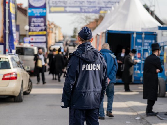 Umundurowany funkcjonariusz Policji podczas zabezpieczenia pielgrzymki Chasydów w Leżajsku.