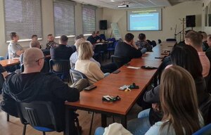 Funkcjonariusze ruchu drogowego z KWP Rzeszów podczas szkolenia inspektorów ITD. Na zdjęciu sala, wyświetlona prezentacja oraz uczestnicy siedzący przy ławkach