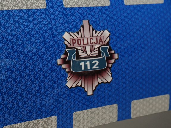 Na zdjęciu widoczna jest policyjna gwiazda z numerem 112 umieszczona na niebieskim tle