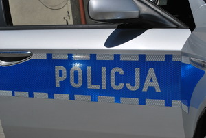Na zdjęciu bok policyjnego radiowozu z napisem policja.