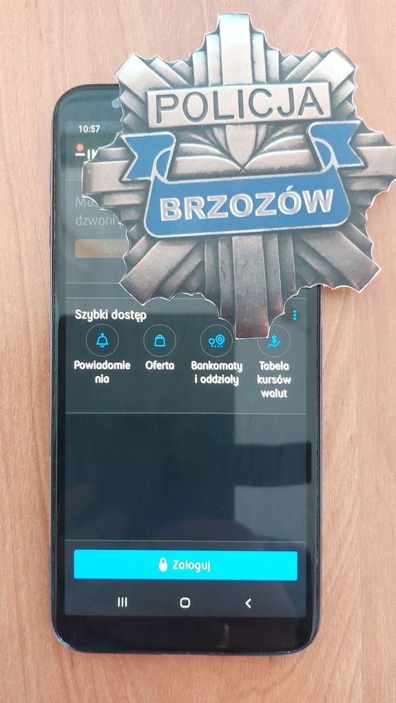 Na zdjęciu widoczny telefon komórkowy z włączoną aplikacją IKO, obok widoczna odznaka policyjna z napisem Policja Brzozów.