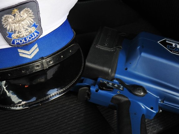 Na zdjęciu widoczna jest czapka policjanta ruchu drogowego oraz ręczny miernik prędkości