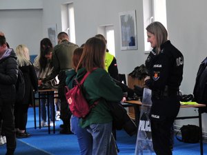Na zdjęciu widoczna jest policjantka opowiadająca o służbie w Policji uczennicom szkół podstawowych