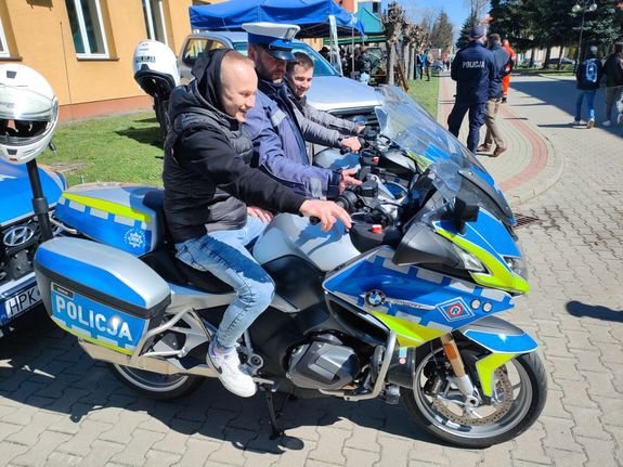 motocykl policyjny wraz z policjantem oraz innym mężczyzną