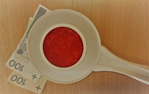 Na zdjęciu widoczna tarcza stop oraz dwa banknoty 100 zł