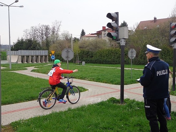 Policjant rd oraz uczestnik turnieju rowerowego podczas jazdy na miasteczku rowegowym