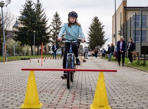 Dziewczynka jedzie na rowerze po torze przeszkód