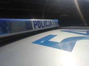 część radiowozu z napisem Policja