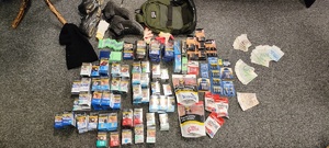 Na zdjęciu przedmioty pochodzące z włamań tj. papierosy, tytoń. A także plecak, rękawiczki, buty pieniądze.