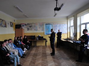 Na zdjęciu widać troje policjantów mówiących do grupy młodzieży