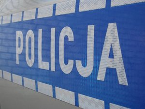 Napis Policja na bocznych drzwiach radiowozu