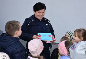Dzieci wręczają policjantce książeczkę