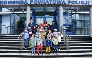 Zdjęcie grupowe dziec, opiekunek i policjantki zrobione przed budynkiem jarosławskiej jednostki
