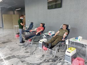 Punkt poboru krwi. Dwie osoby oddają krew.