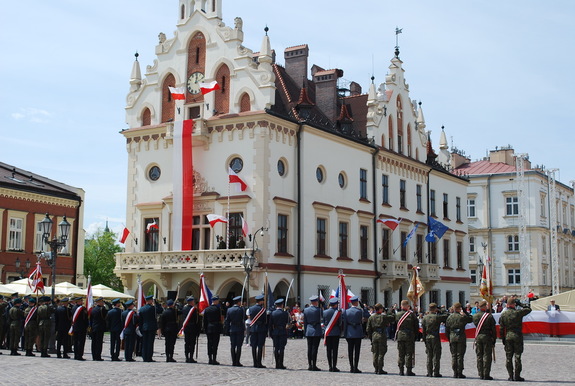 Na zdjęciu Ratusz w Rzeszowie i stojące tyłem poczty sztandarowe służb mundurowych.