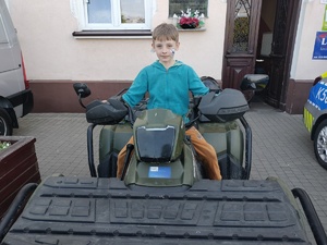 Na zdjęciu uczestnik pikniku, siedzi na quadzie policyjnym.