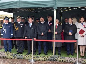 na zdjęciu trybuna honorowa, stojący przedstawiciele władz administracyjnych i samorządowych oraz przedstawiciele służb mundurowych