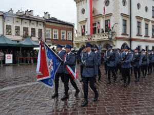na zdjęciu defilada podoodziału Policji wraz ze sztandarem przed trybuną honorową