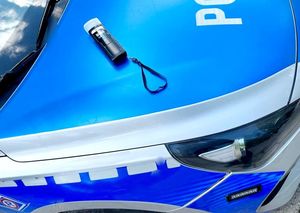 na pokrywie silnika radiowozu osobowego leży urządzenie do badania stanu trzeźwości