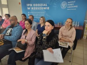 Siedzące na krzesłach w sali osoby - uczestnicy szkolenia podczas spotkania