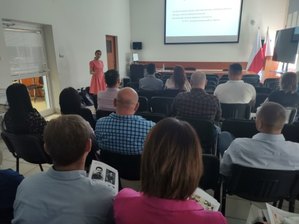 Siedzące na krzesłach w sali osoby - uczestnicy szkolenia podczas spotkania