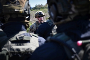 Policyjni antyterroryści i amerykańscy żołnierze podczas wspólnych ćwiczeń, na terenie zielonym.