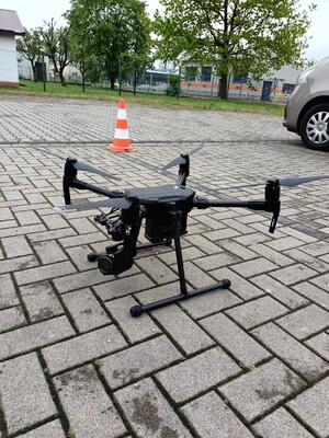 Na zdjęciu znajduje się policyjny dron. W tle kostka brukowa.