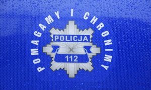odznaka policyjna na niebieskim tle z napisem pomagamy i chronimy
