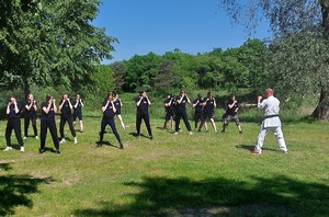 Na zdjęciu uczestnicy obozu podczas treningu ze sztuk walki wraz z instruktorem.