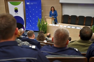 Policjanci i zaproszeni goście podczas konferencji w auli Uniwersytetu Rzeszowskiego. Uczestnicy siedzą w ławkach.