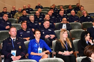 Policjanci i zaproszeni goście podczas konferencji w auli Uniwersytetu Rzeszowskiego. Uczestnicy siedzą w ławkach.