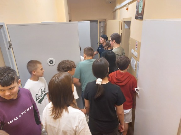 Uczniowie oglądają pomieszczenia dla osób zatrzymanych.