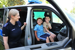 Policjantka i dwójka chłopców wewnątrz radiowozu