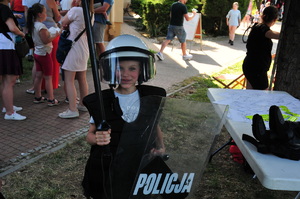 Chłopiec ubrany w policyjny sprzęt służbowy służący do zabezpieczenia imprez masowych